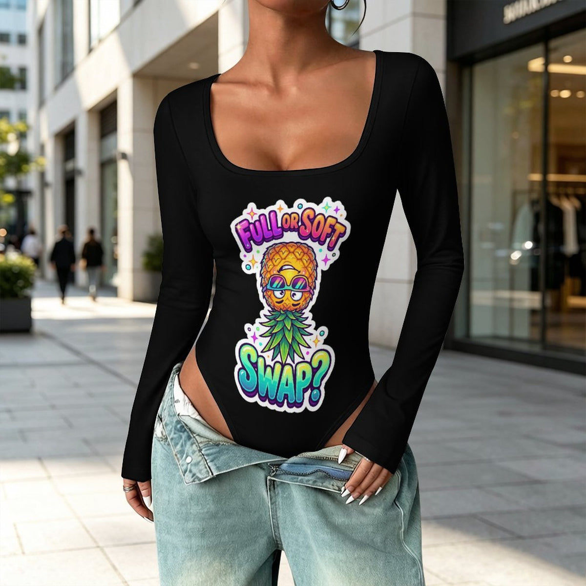 A woman wearing a black long-sleeve bodysuit with a colorful pineapple graphic and the text 'FULL OR SOFT SWAP?' in a city street setting.