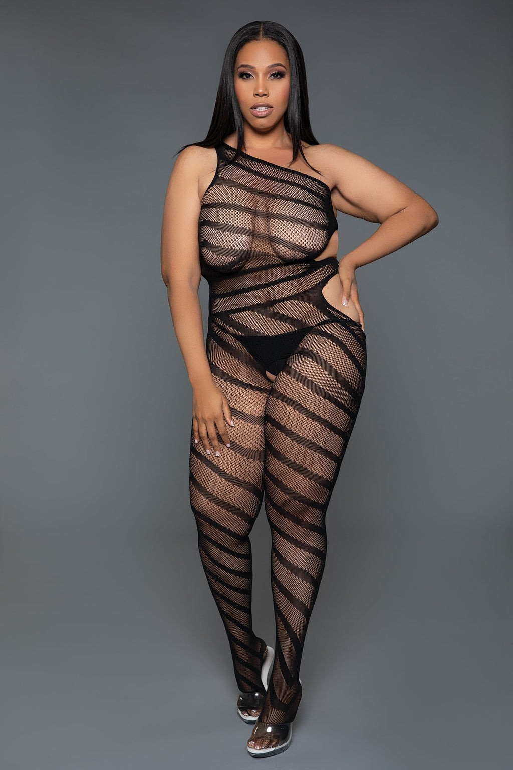 Person wearing a black fishnet bodysuit against a gray background