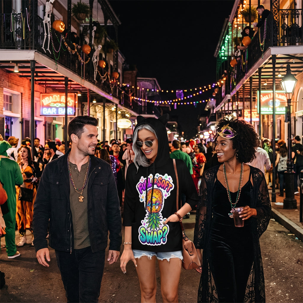 Three people walking down a lively, Halloween-decorated street at night. The central person wears a black hoodie with a colorful graphic print that reads 'WHEN DO MY TONSURE TIGERS LOOK LIKE YOU?' and denim shorts.