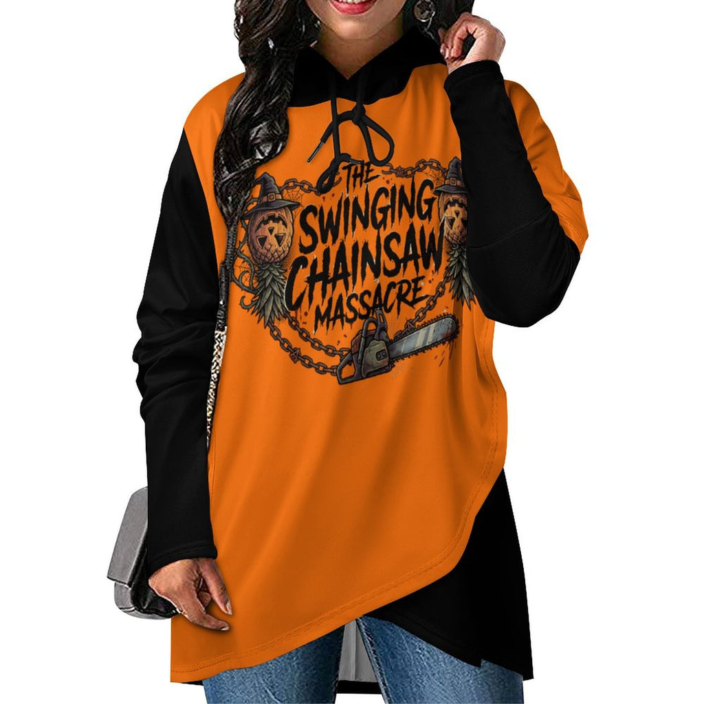 A woman wearing a long-sleeve hoodie with a bright orange body, black sleeves and hood, featuring a large graphic print on the front that reads 'The Swinging Chainsaw Massacre' with a chainsaw, skulls, and decorative illustration.