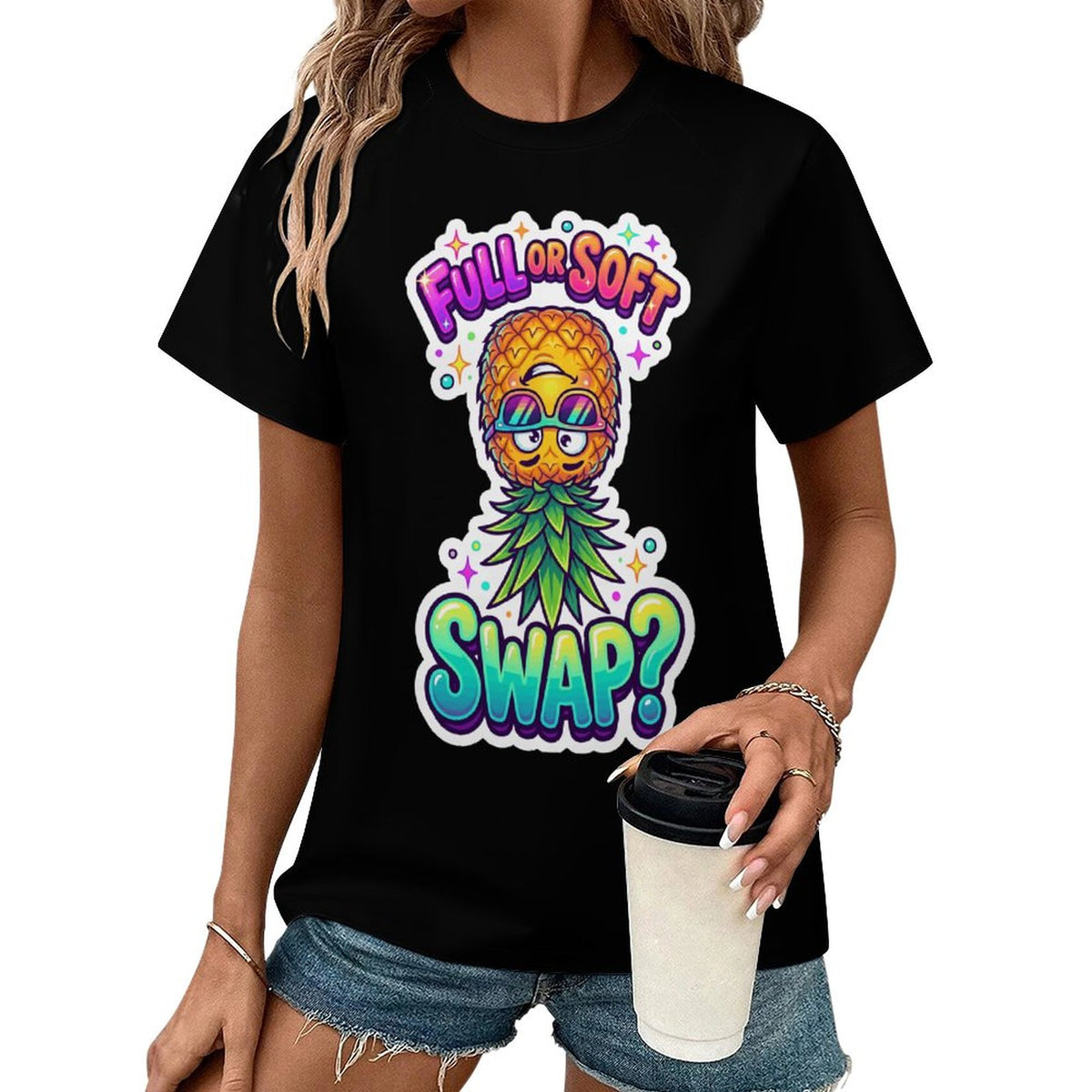 A woman wearing a black short-sleeve graphic T-shirt with a colorful pineapple wearing sunglasses and the text 'FULL OR SOFT SWAP?' on the front, paired with denim shorts and holding a white takeaway cup against a plain white background.