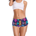 Woman wearing a white sports bar and neon pineapple boyshorts.