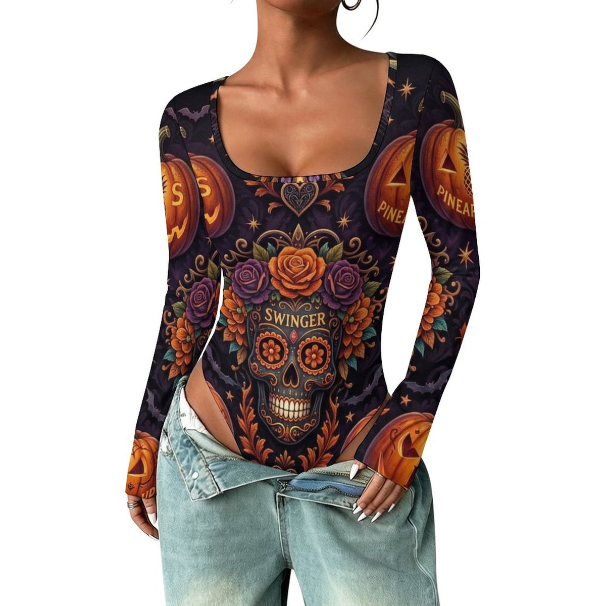 A woman wearing a long-sleeve scoop-neck bodysuit with a colorful Day of the Dead sugar skull and jack-o'-lantern print on a black background, paired with light-wash denim jeans.