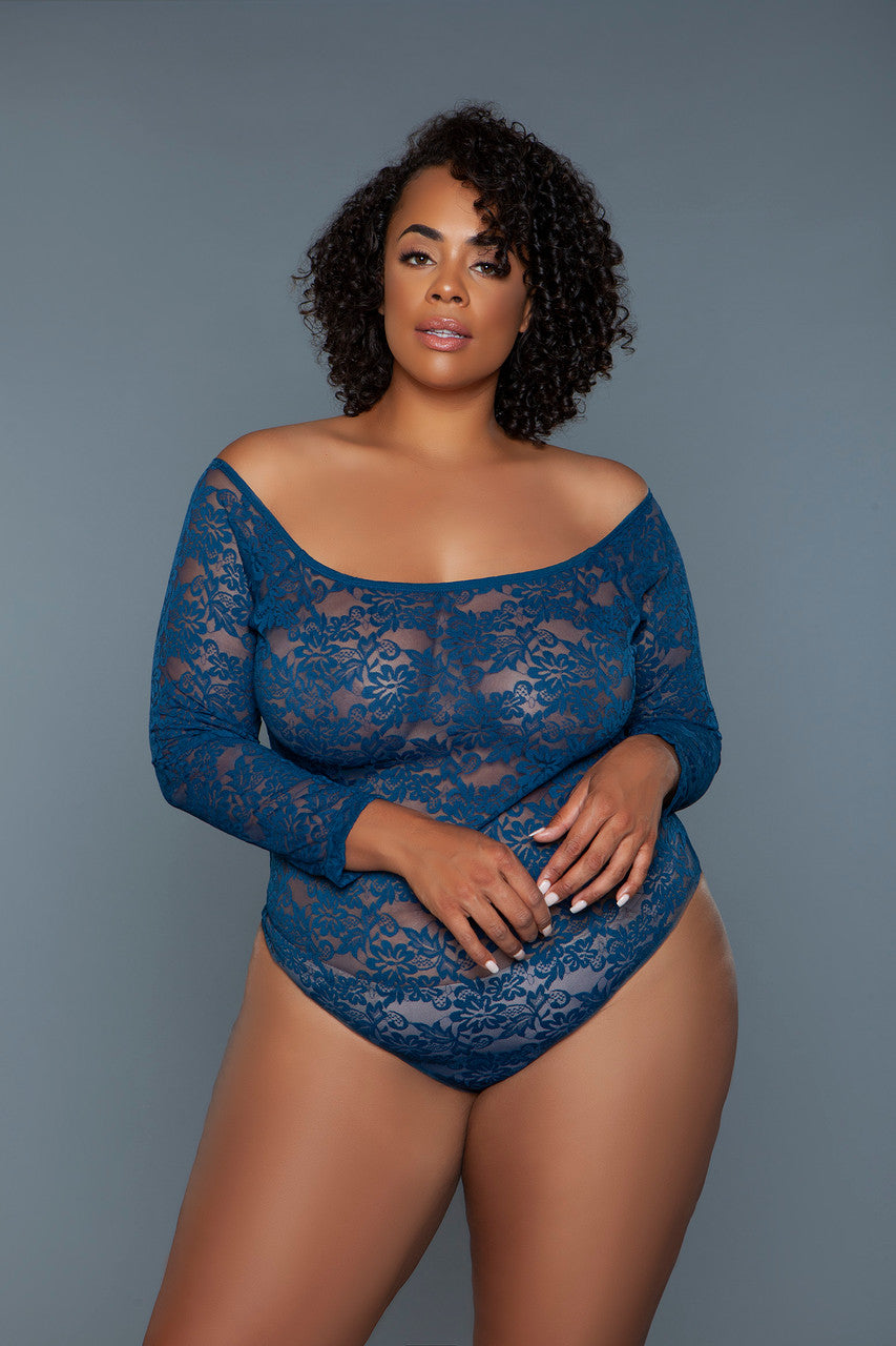 Woman wearing a blue lace bodysuit against a gray background