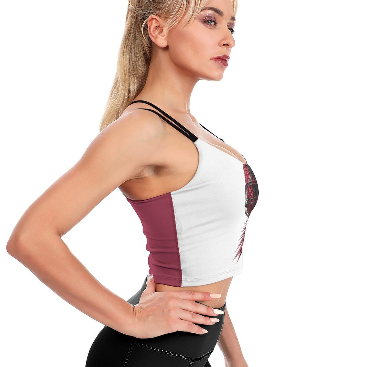 A woman in profile wearing a color-blocked sports bra with white, burgundy, and black panels, paired with black athletic bottoms, against a solid white background.