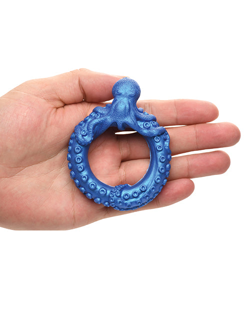 Blue octopus-shaped teething ring held in a hand against a white background