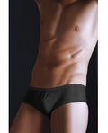 Man wearing black underwear against a dark background