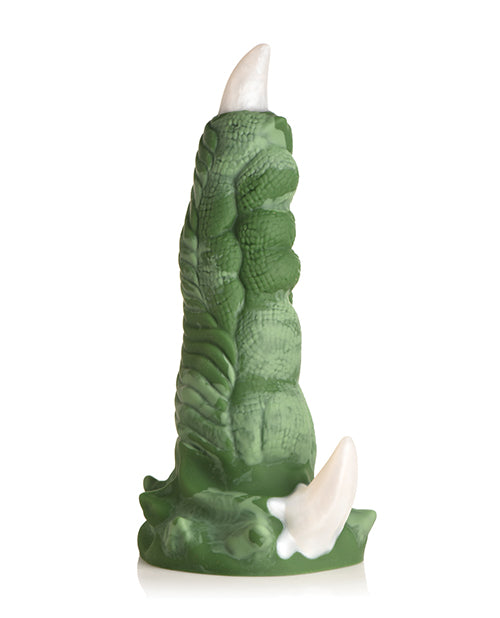 Green leaf-patterned candle with white wick on a white background