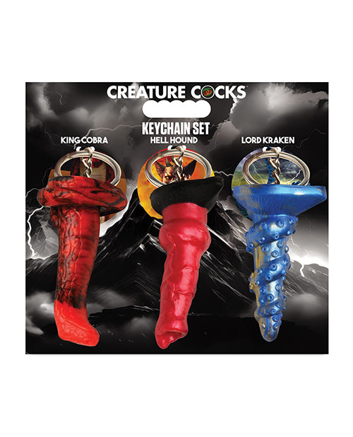 Packaged keychain set of 'Creature Cocks' with three different designs on a dark background.
