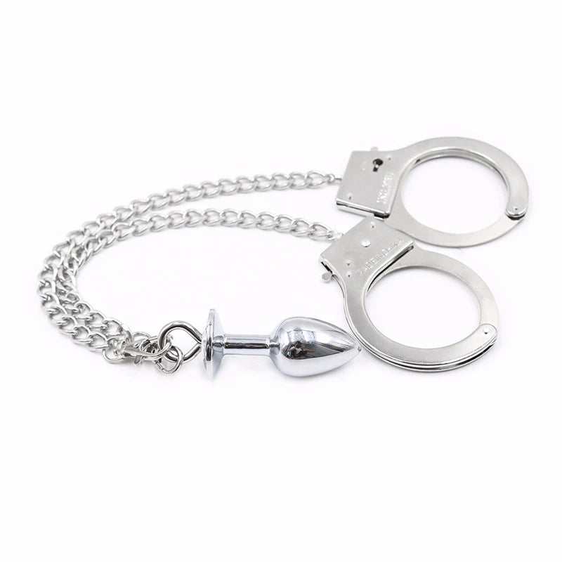 BDSM handcuffs with a chain that leads to a silver anal plug. Represents the BDSM community.