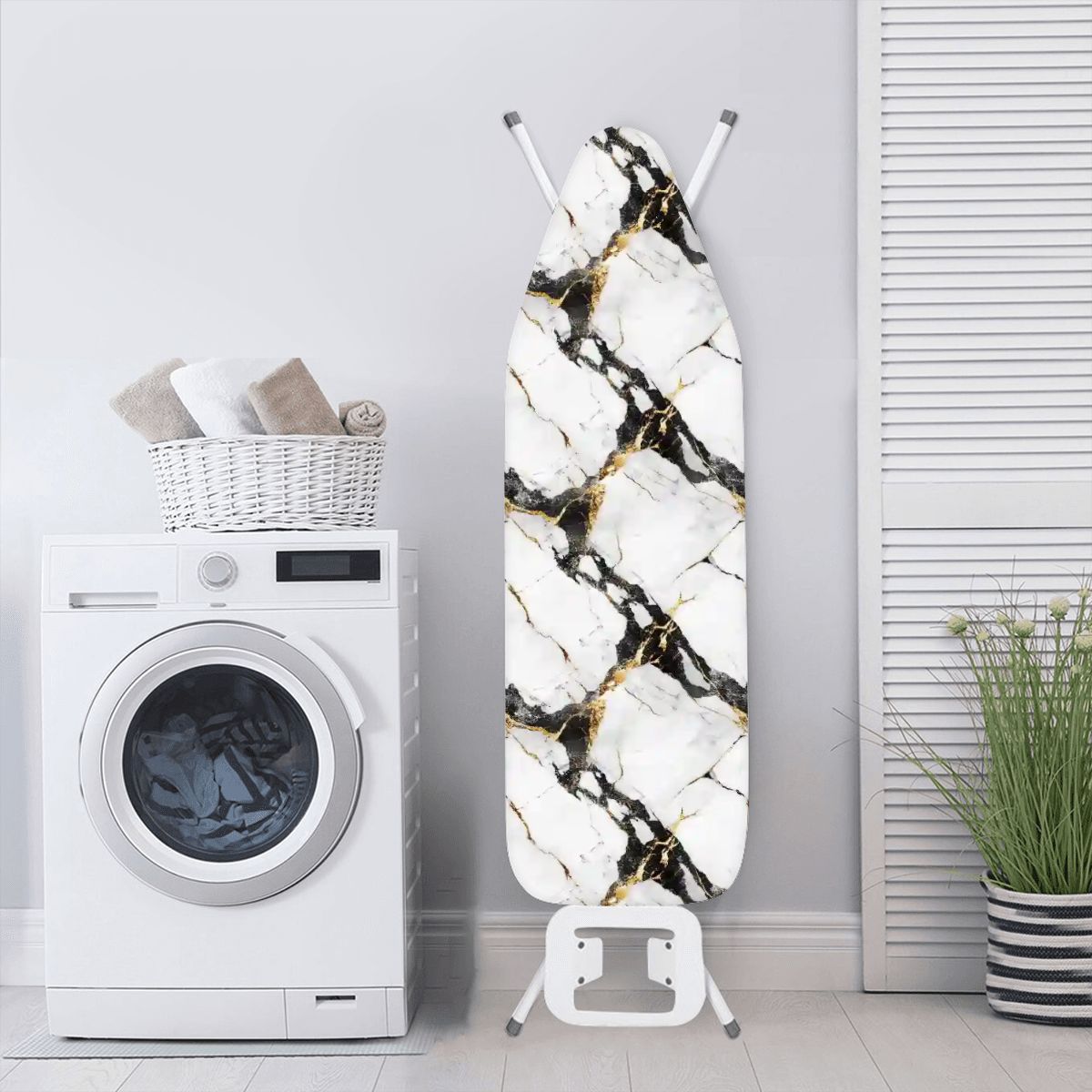 Black and gold marble colored ironing board cover on an ironing board in a laundry room. The ironing board is standing next to a washing machine.