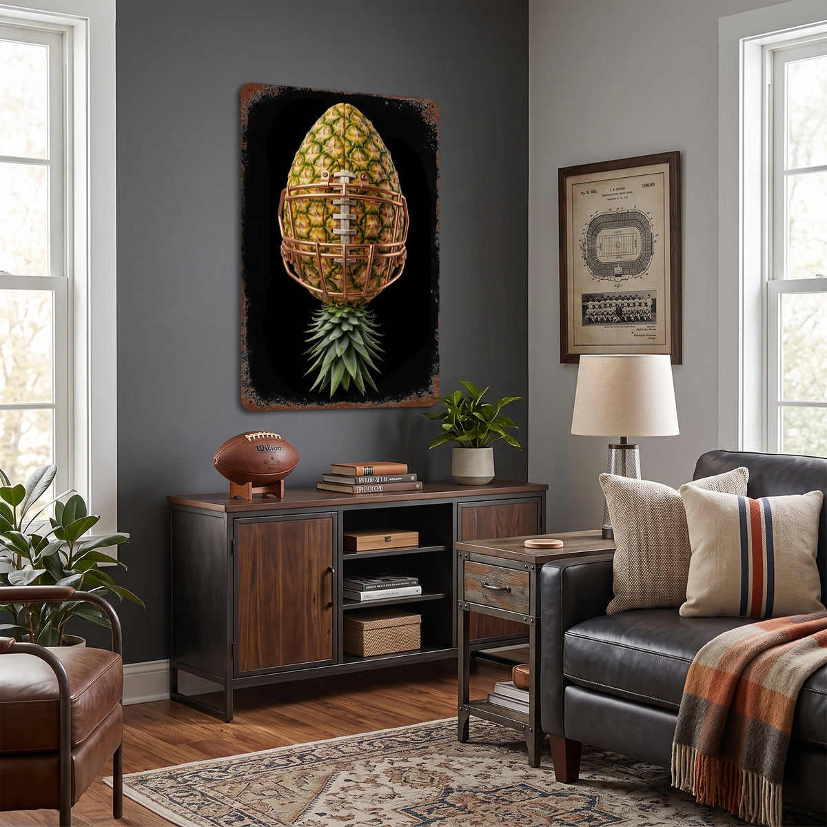 A framed wall art print featuring a stylized pineapple with a basketball net pattern on a black background, displayed in a modern living room setting above a dark wood credenza.