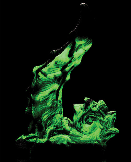 Glowing green dragon sculpture on a black background