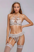 Woman wearing a white lace lingerie set with a veil on a plain background. Perfect for a bridal boudoir photoshoot or a swinger lifestyle event.